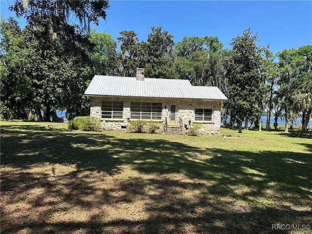 3184 N Edward Island Pt, Hernando, FL 34442 - view of front of home with stone siding, a chimney, a front lawn, metal roof, and entry steps