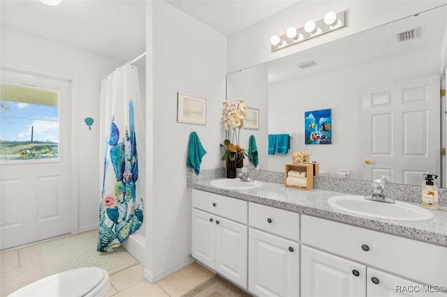 bathroom with tile patterned floors, a shower with curtain, vanity, and toilet