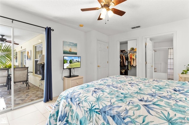 tiled bedroom featuring a textured ceiling, ensuite bath, and ceiling fan