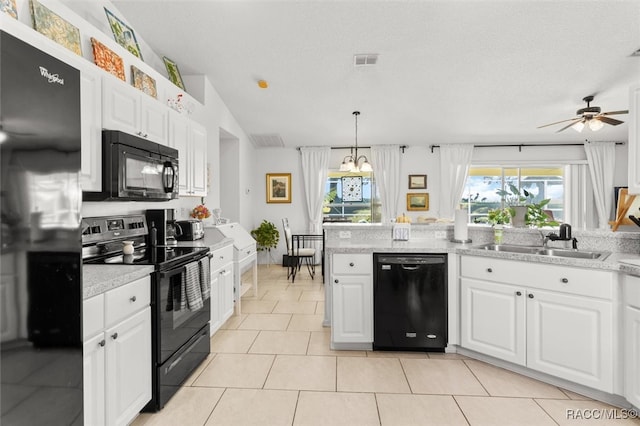 kitchen with black appliances, decorative light fixtures, light tile patterned flooring, and white cabinetry