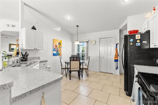 kitchen featuring white cabinets, sink, hanging light fixtures, vaulted ceiling, and light tile patterned flooring