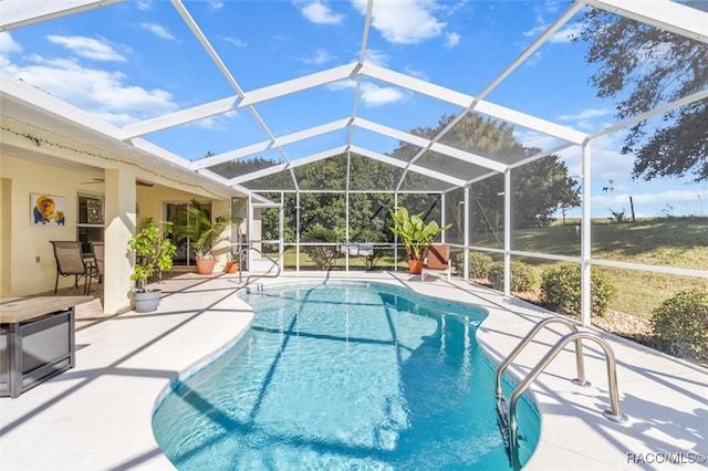 view of pool featuring glass enclosure, ceiling fan, and a patio area