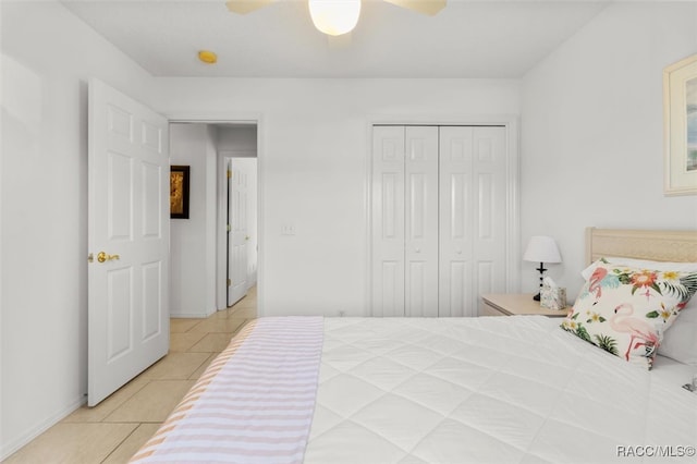 bedroom with light tile patterned floors, a closet, and ceiling fan