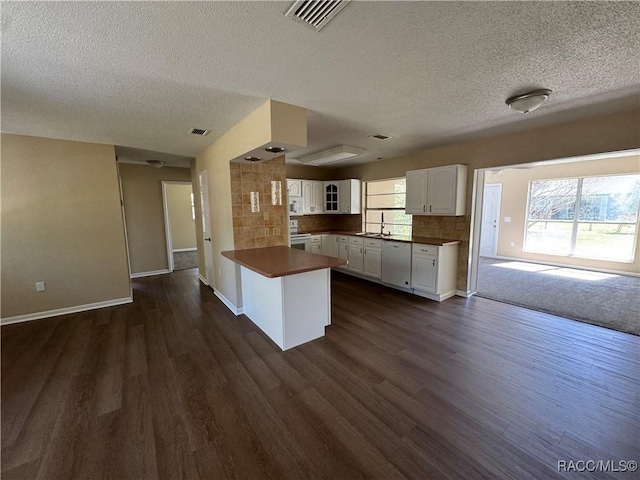 kitchen featuring white cabinetry, white appliances, a peninsula, and a wealth of natural light