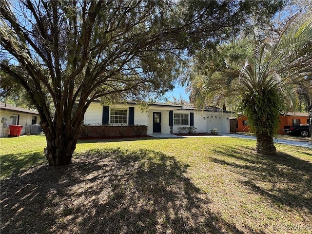 single story home featuring a front lawn, central AC unit, and a garage