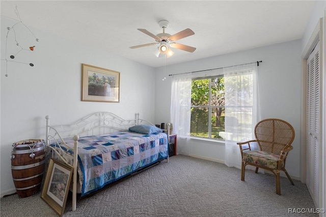 bedroom featuring a ceiling fan, carpet, a closet, and baseboards