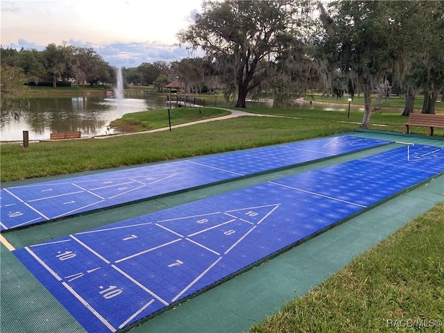 view of home's community featuring shuffleboard, a yard, and a water view