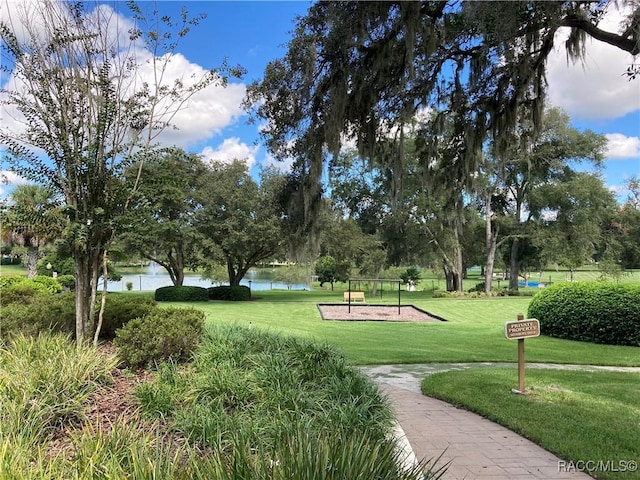 view of community with a lawn and a water view