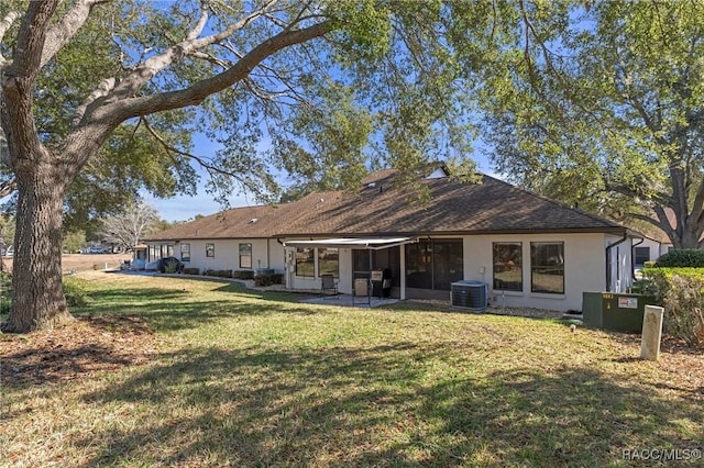 back of house featuring central AC, a yard, and a patio