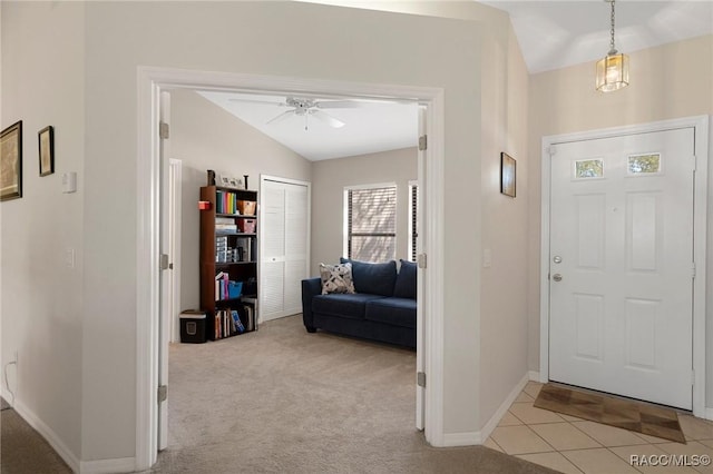 foyer entrance featuring ceiling fan, light colored carpet, and lofted ceiling