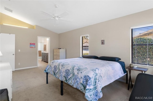 carpeted bedroom with connected bathroom, vaulted ceiling, and ceiling fan