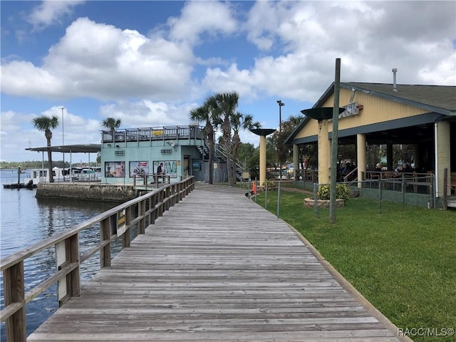 dock area featuring a water view and a lawn