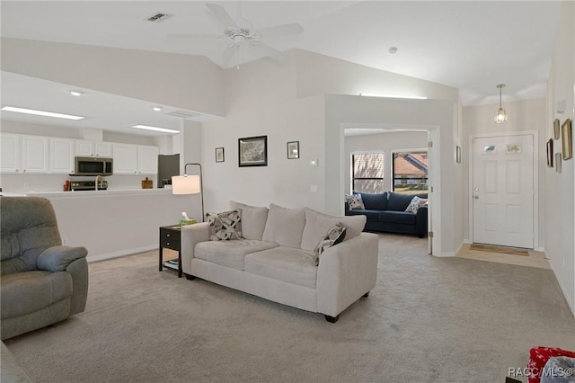 living room with ceiling fan, light colored carpet, and lofted ceiling