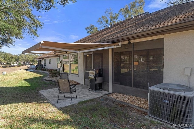 rear view of property featuring a yard, a patio area, and central air condition unit