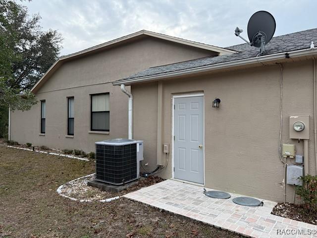 rear view of house featuring central AC