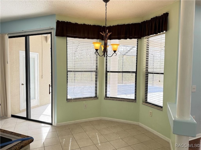 unfurnished dining area with a notable chandelier, a textured ceiling, and light tile patterned floors