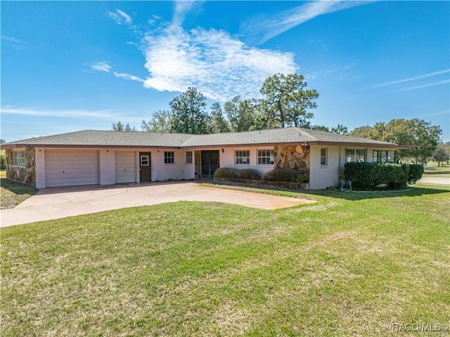 ranch-style home featuring a garage, a front yard, concrete driveway, and stucco siding