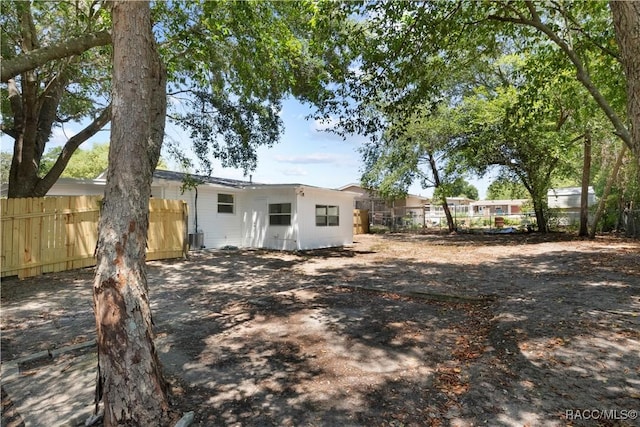 rear view of house featuring fence and cooling unit