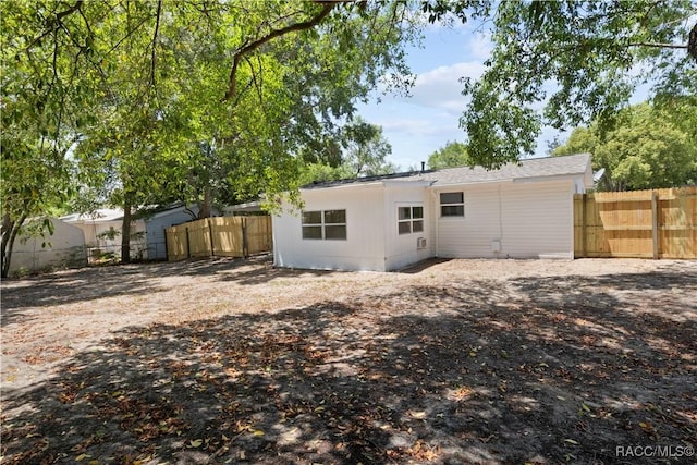 rear view of house with a fenced backyard