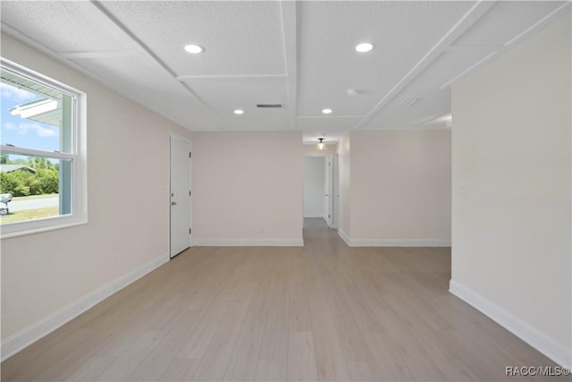 empty room with baseboards, recessed lighting, light wood-style flooring, and visible vents