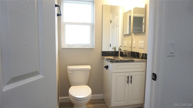 bathroom featuring plenty of natural light, vanity, and toilet