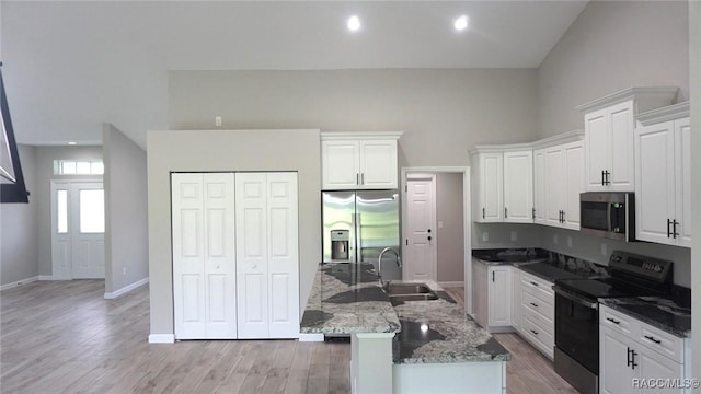 kitchen featuring high vaulted ceiling, dark stone counters, white cabinets, sink, and stainless steel appliances