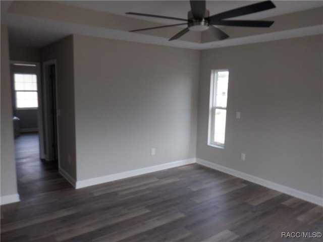 empty room with dark wood-type flooring and ceiling fan