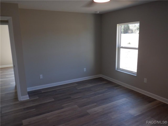 spare room featuring plenty of natural light and dark wood-type flooring