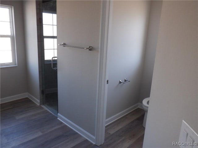 bathroom featuring hardwood / wood-style flooring, toilet, and walk in shower