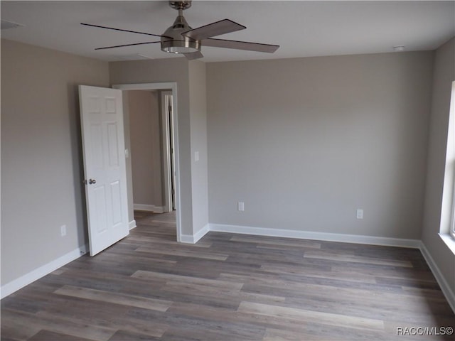 empty room featuring dark hardwood / wood-style flooring and ceiling fan