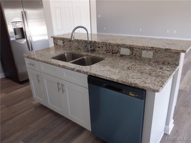 kitchen featuring sink, appliances with stainless steel finishes, white cabinetry, light stone countertops, and dark hardwood / wood-style flooring