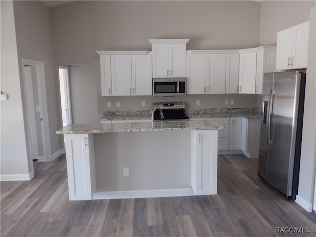 kitchen with a kitchen island with sink, white cabinets, and appliances with stainless steel finishes