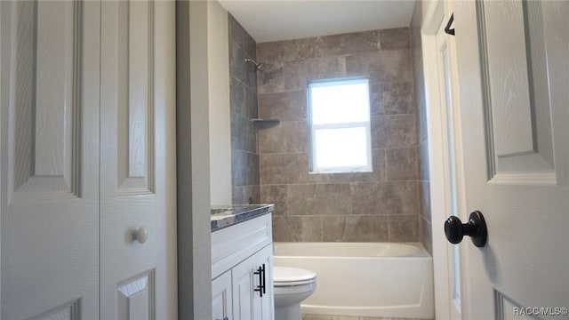 full bathroom featuring vanity, toilet, and tiled shower / bath