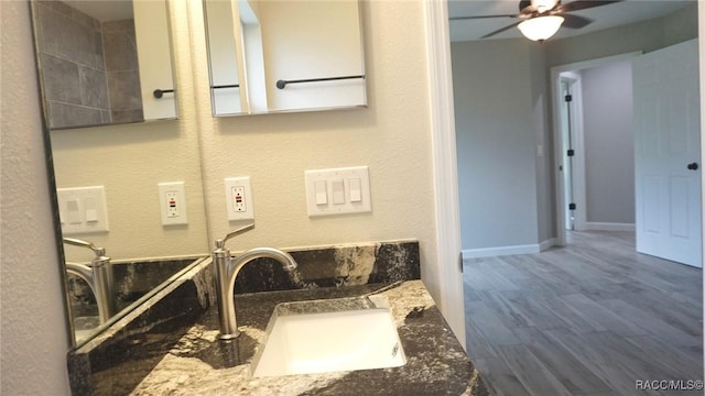 bathroom featuring ceiling fan, hardwood / wood-style floors, and vanity