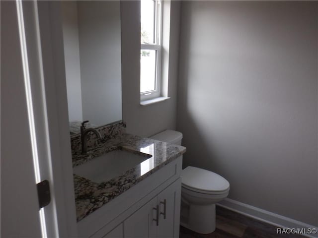 bathroom with vanity, toilet, and hardwood / wood-style floors