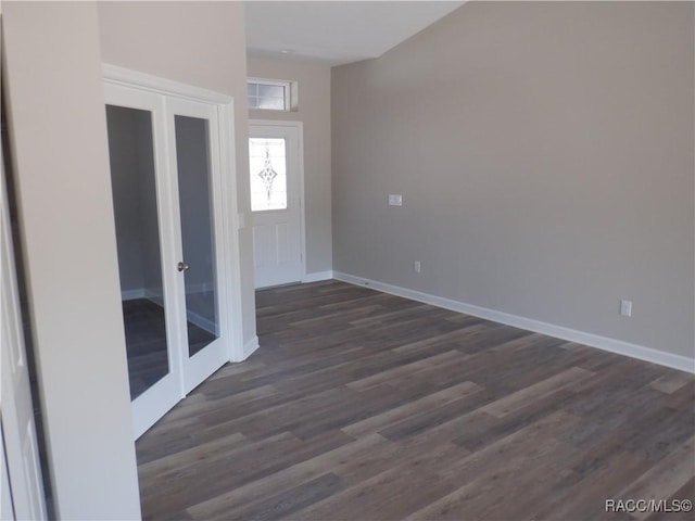 spare room with dark hardwood / wood-style flooring and french doors