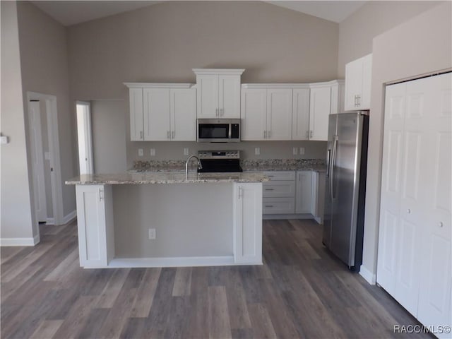 kitchen with white cabinetry, light stone countertops, and stainless steel appliances