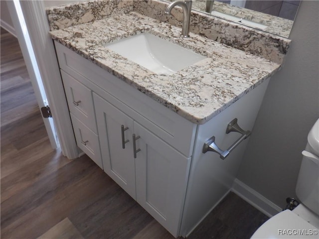 bathroom with vanity, hardwood / wood-style floors, and toilet