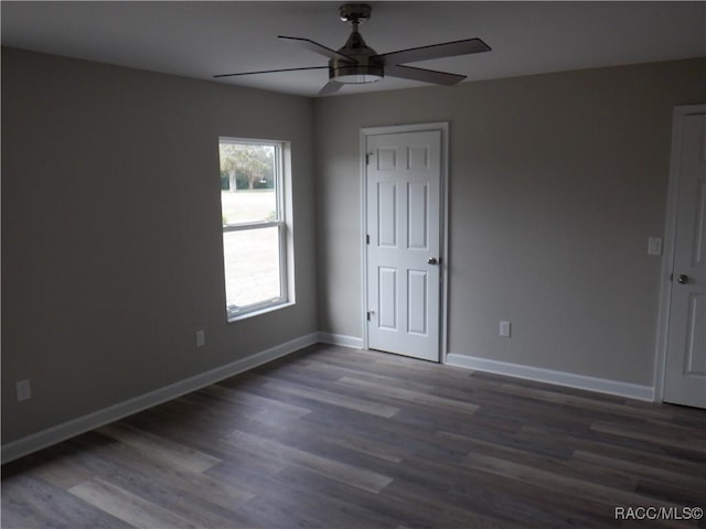 spare room with dark wood-type flooring and ceiling fan