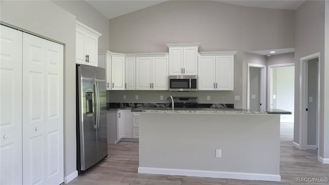 kitchen with dark stone counters, white cabinetry, and stainless steel appliances