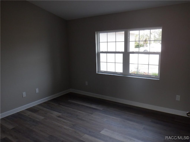 empty room with plenty of natural light and dark wood-type flooring