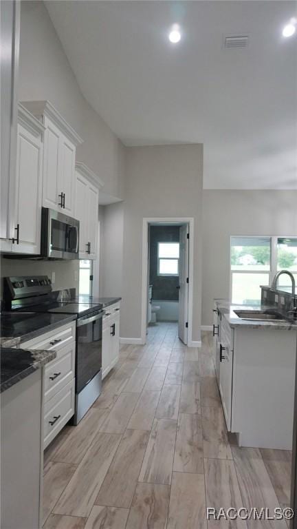 kitchen with sink, white cabinetry, and stainless steel appliances