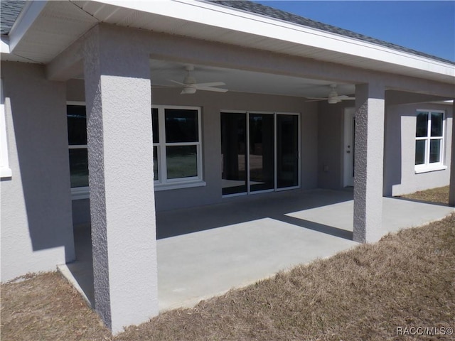 rear view of house featuring ceiling fan and a patio area