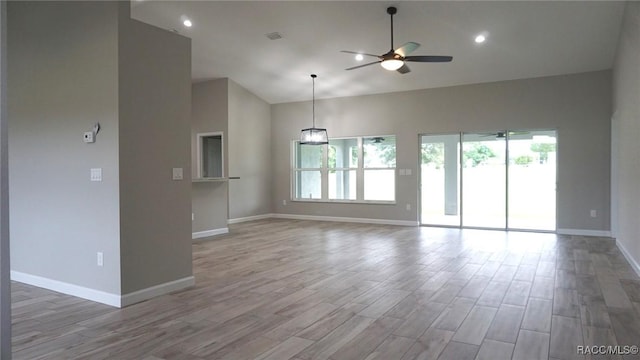 unfurnished living room featuring ceiling fan, light hardwood / wood-style floors, and a towering ceiling