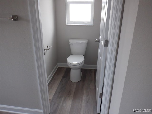 bathroom with hardwood / wood-style floors and toilet