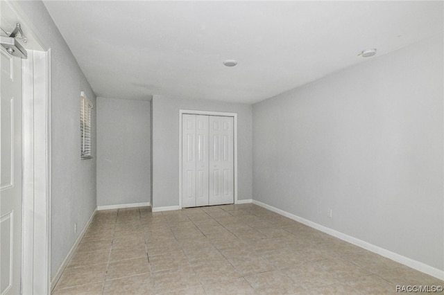 unfurnished bedroom with a closet and light tile patterned floors