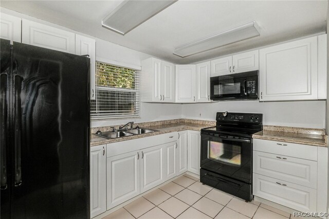 kitchen featuring white cabinetry, sink, light tile patterned floors, and black appliances