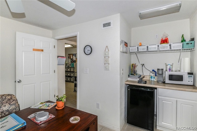 kitchen with white cabinets, black dishwasher, and ceiling fan