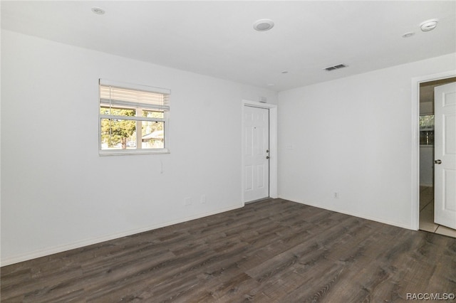 empty room with dark hardwood / wood-style flooring