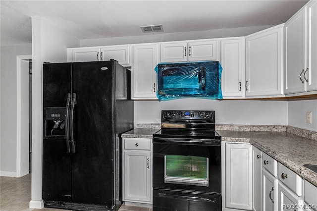 kitchen with white cabinetry, light tile patterned floors, black appliances, and light stone counters